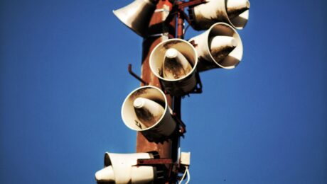megaphone speakers on wooden post